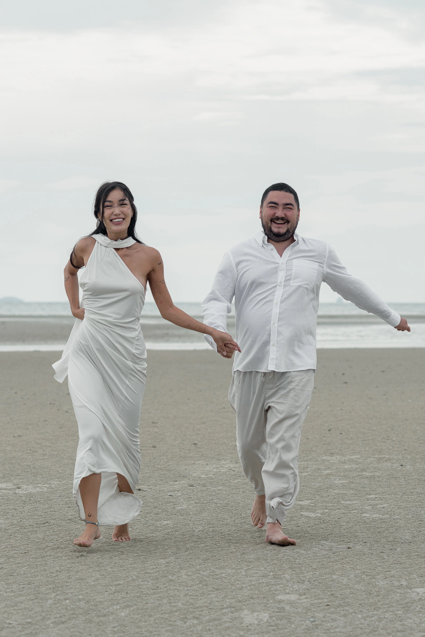 Couple running together along the beach