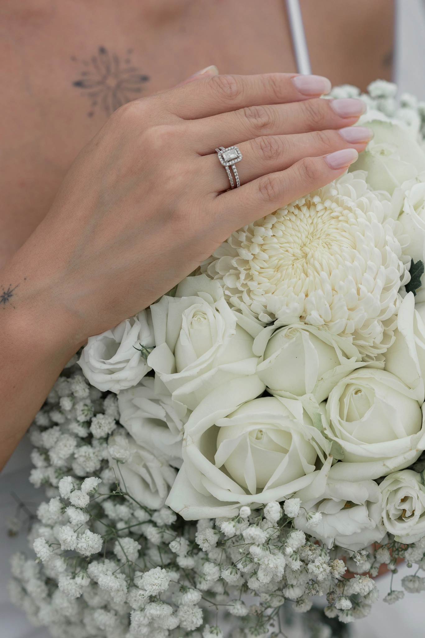 Close view of the bride's hand, ring and white bouquet
