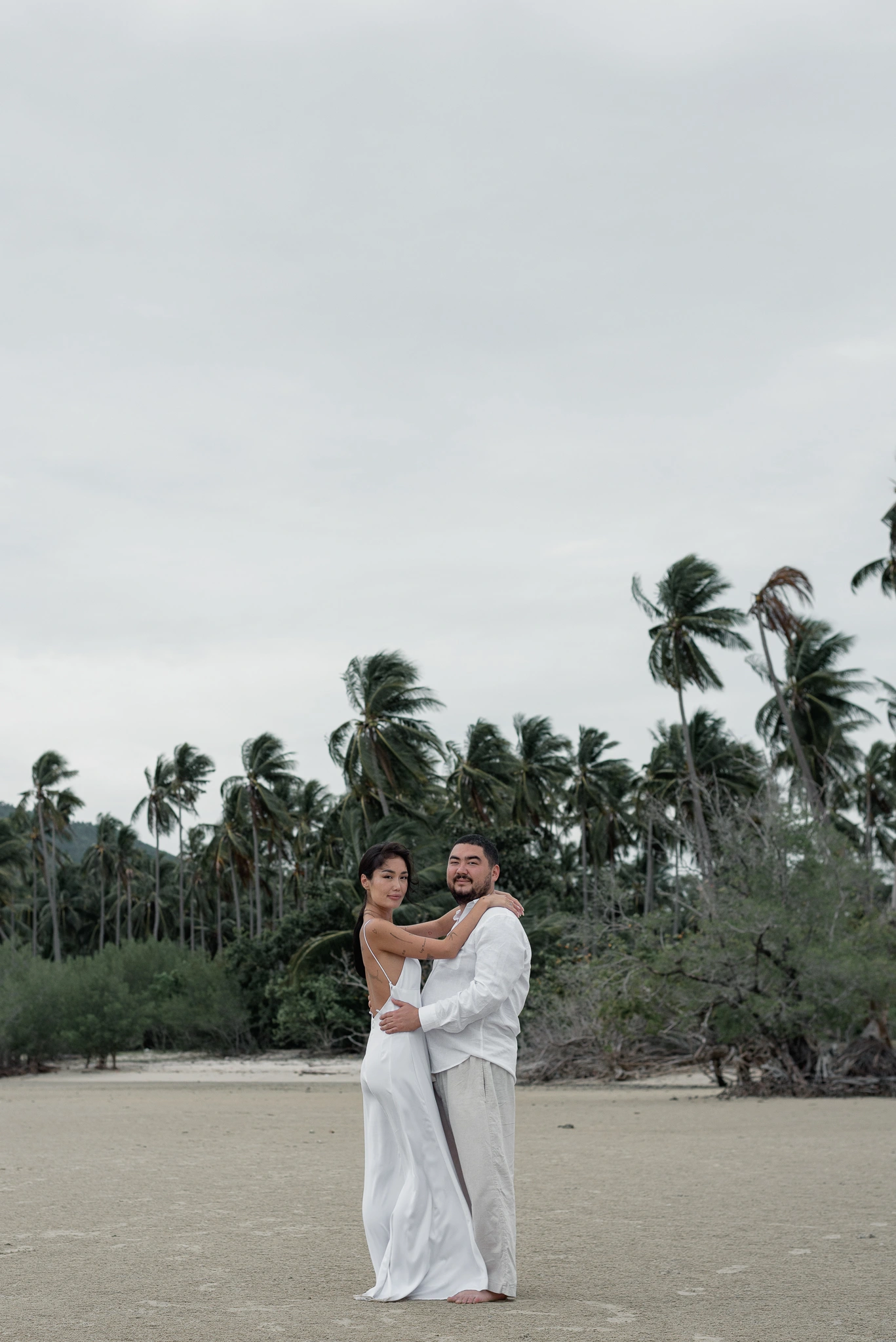 Couple standing together in a quiet tropical beach landscape