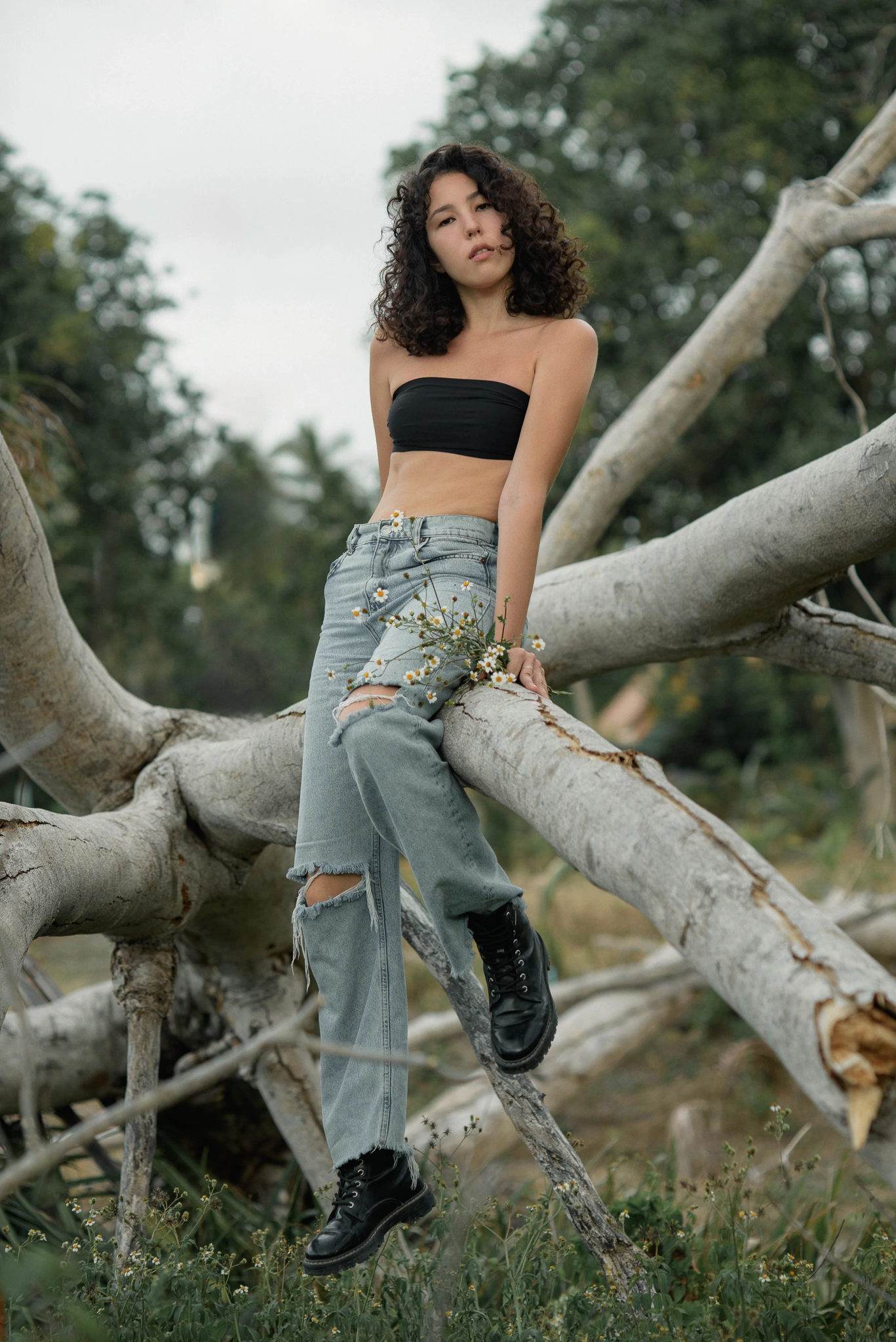 Fashion model posing among pale tree branches