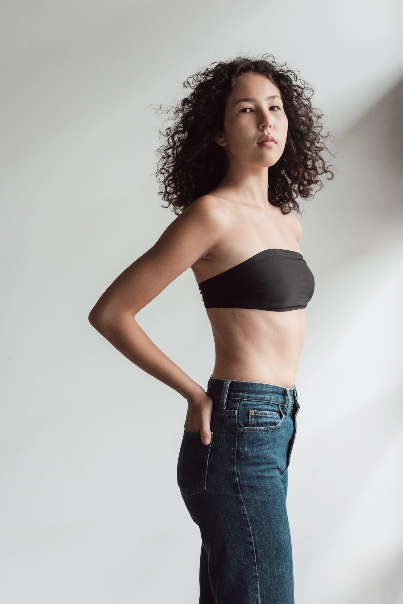 Model turning her torso in directional window light